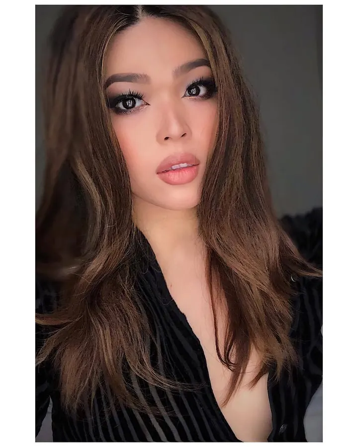 Femme en tenue noire, regardant la caméra, souriante