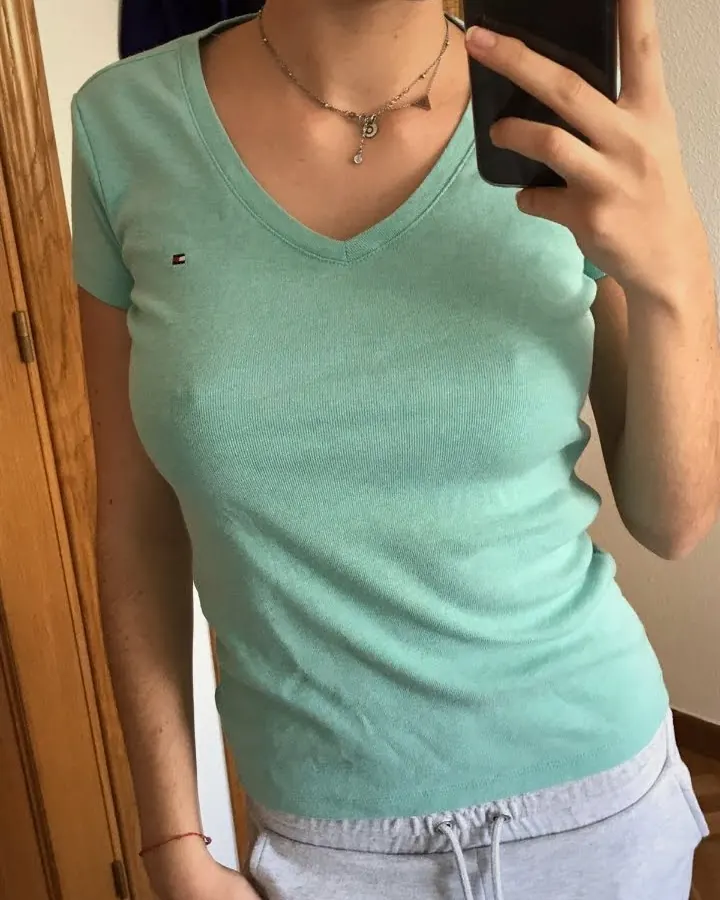 Femme en t-shirt vert, prenant un selfie, regardant la caméra