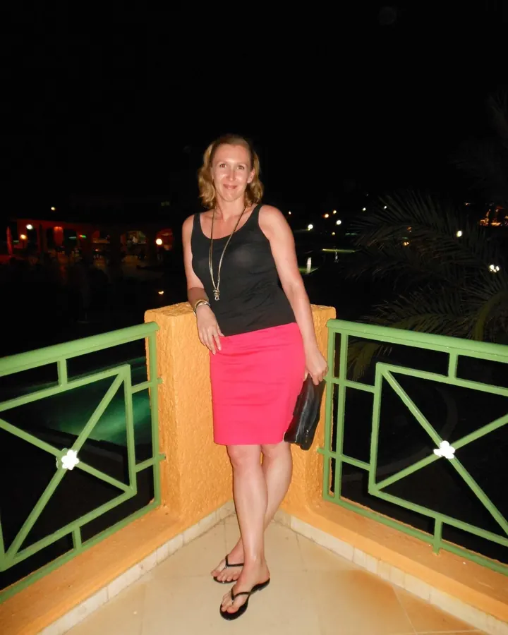 Femme en haut noir, posant sur un canapé, souriante