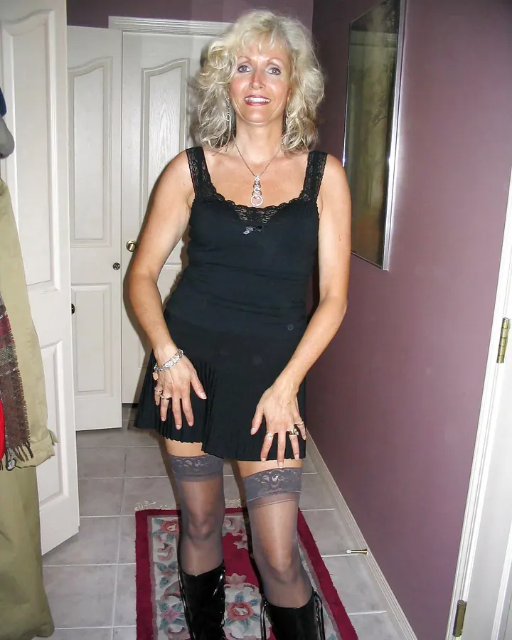 femme blonde en robe noire courte et bottes, porte d’entrée